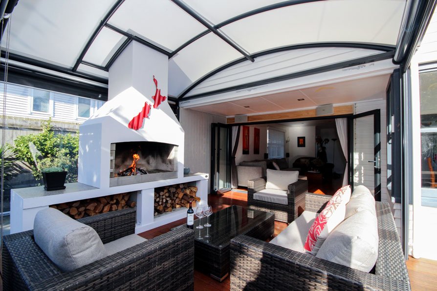 outdoor room with fireplace covered by a fresco canopy