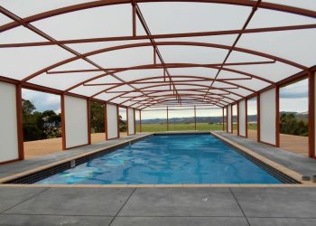 Free standing arched canopy covering a pool by Fresco Shades